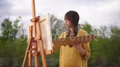 一个成年女人拿着油画颜料画着静物
